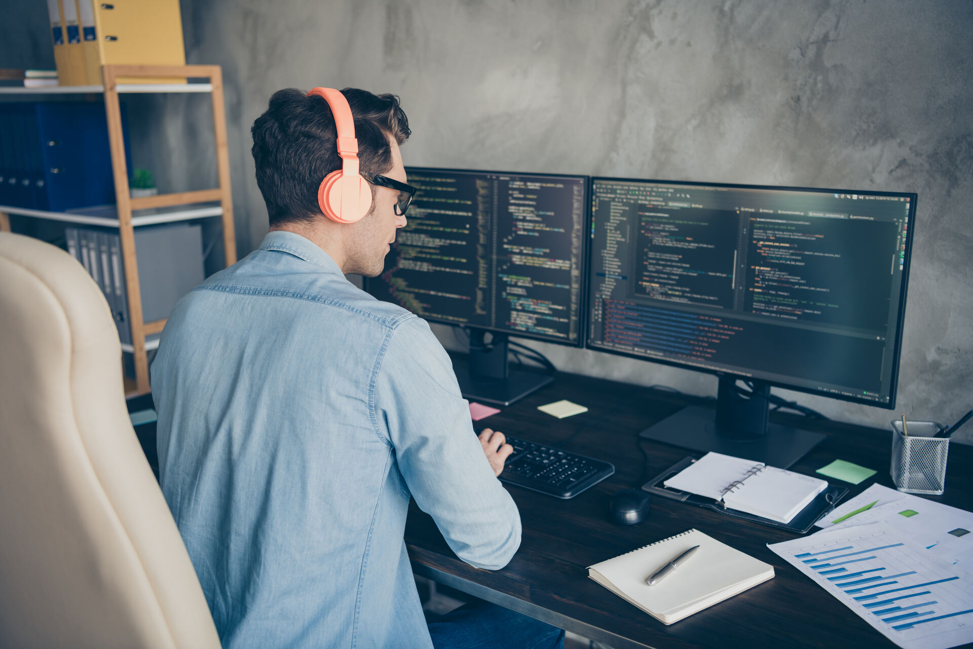 A man with headphones working on a computer