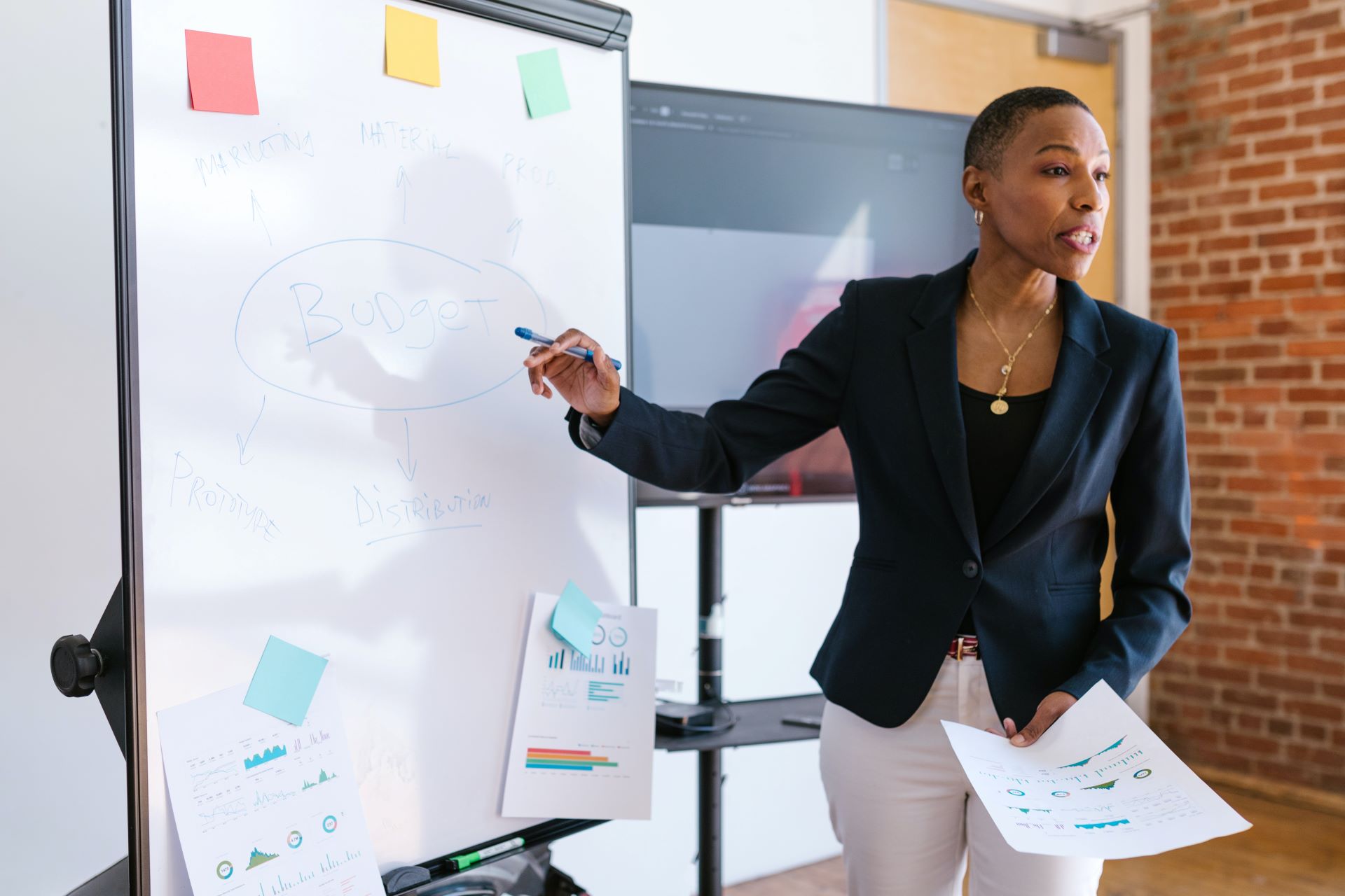 A woman giving a lecture in front of a whiteboard