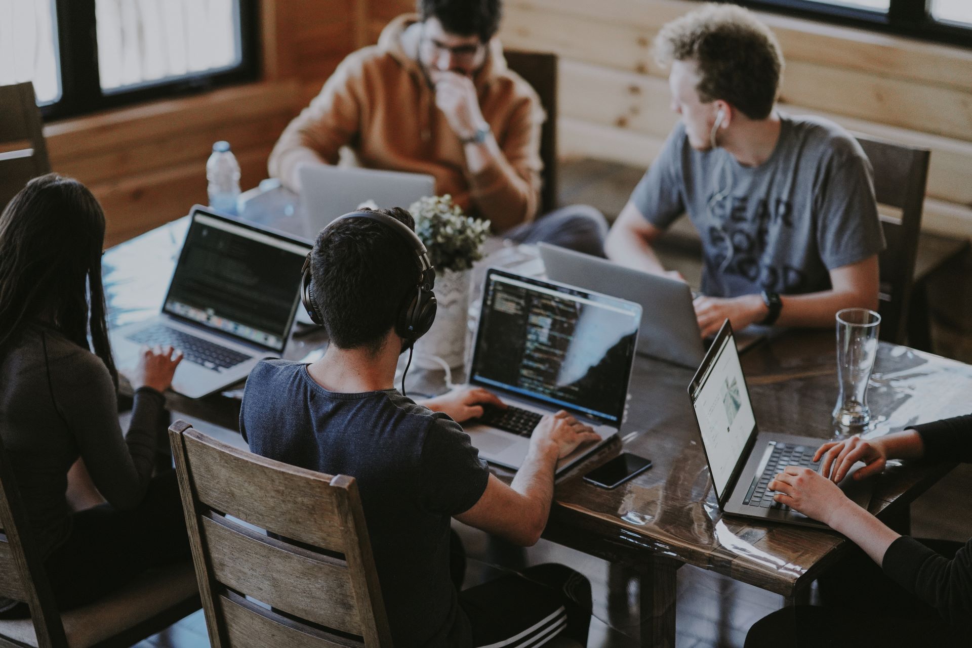 Five people sitting at the table and working on their laptops