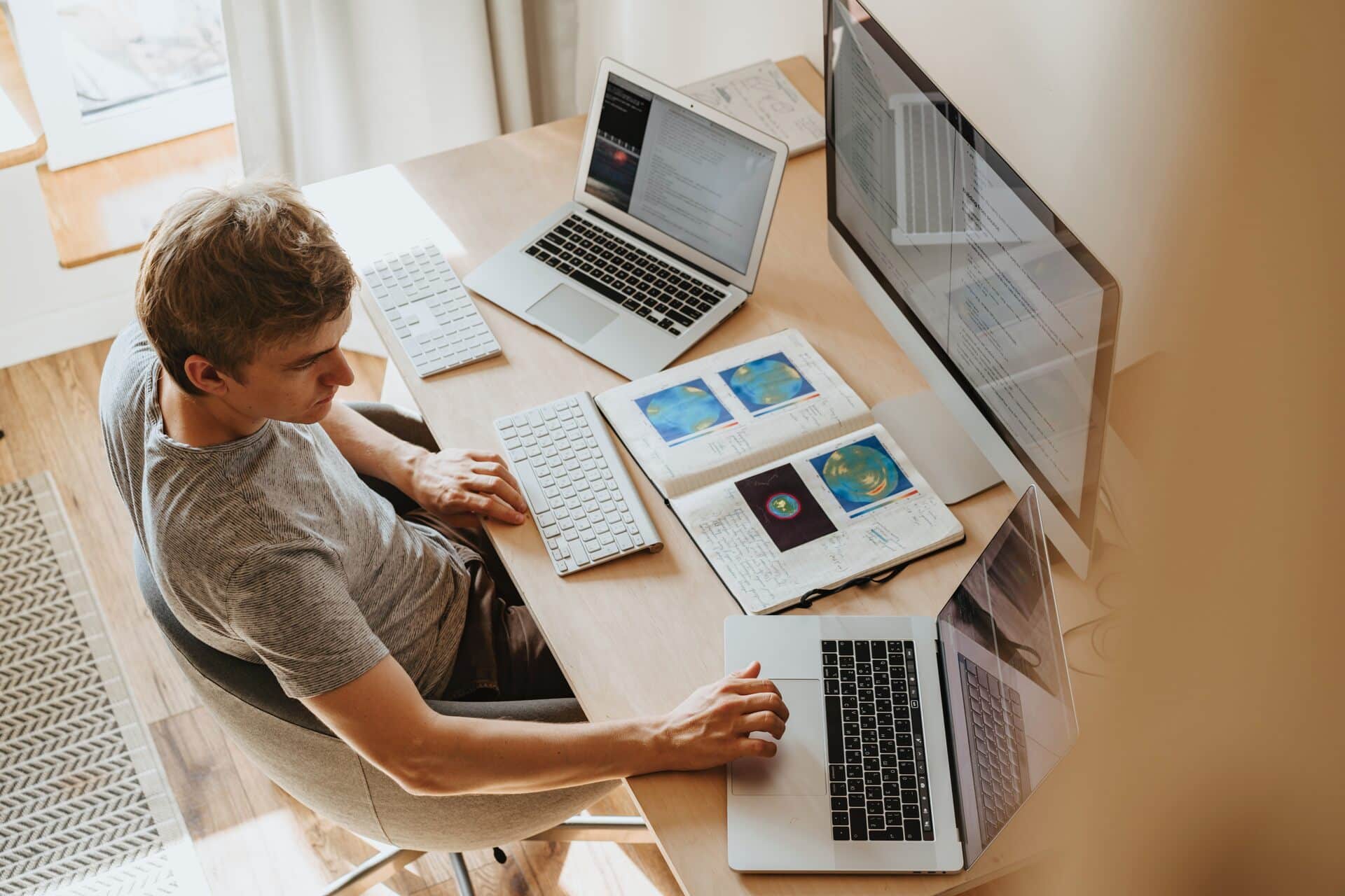 A man using a computer and two laptops