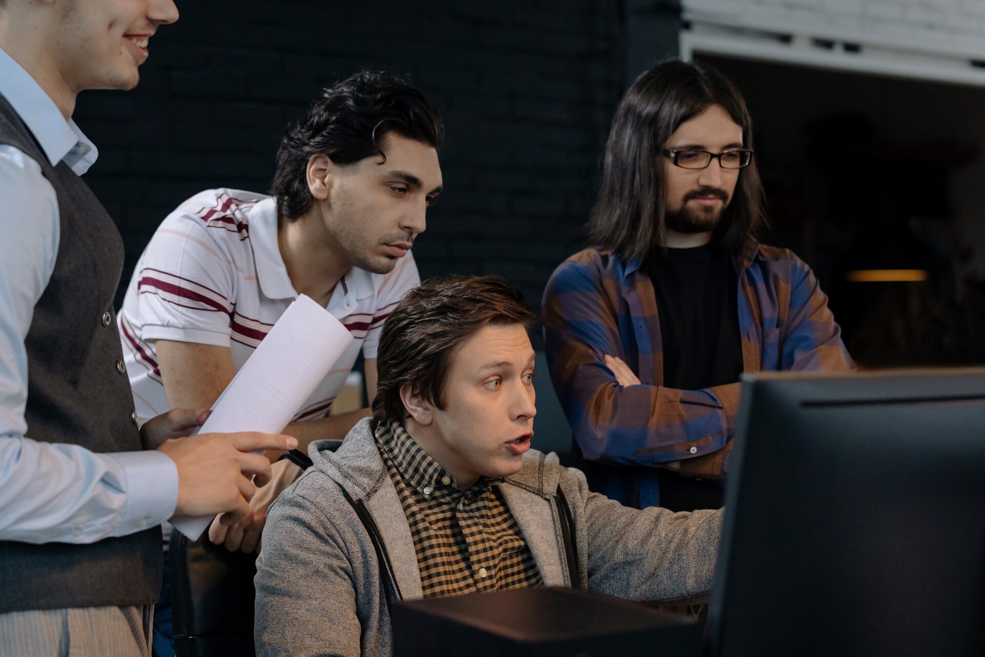 A group of men looking at a screen