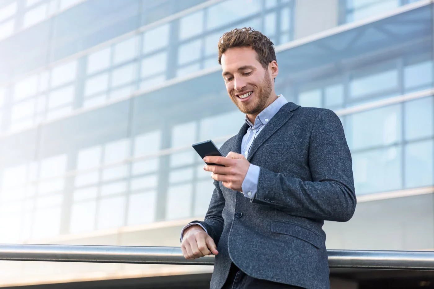 A man looking at his smartphone and smiling