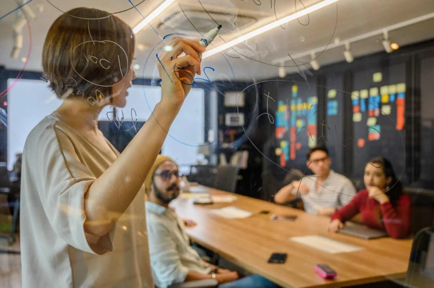 A woman writing on a board during a meeting