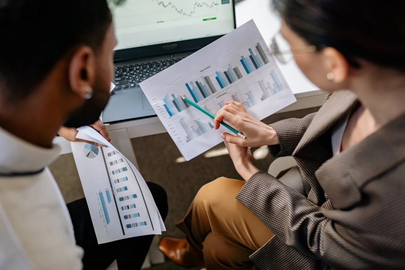 Two people discussing graphs on printout