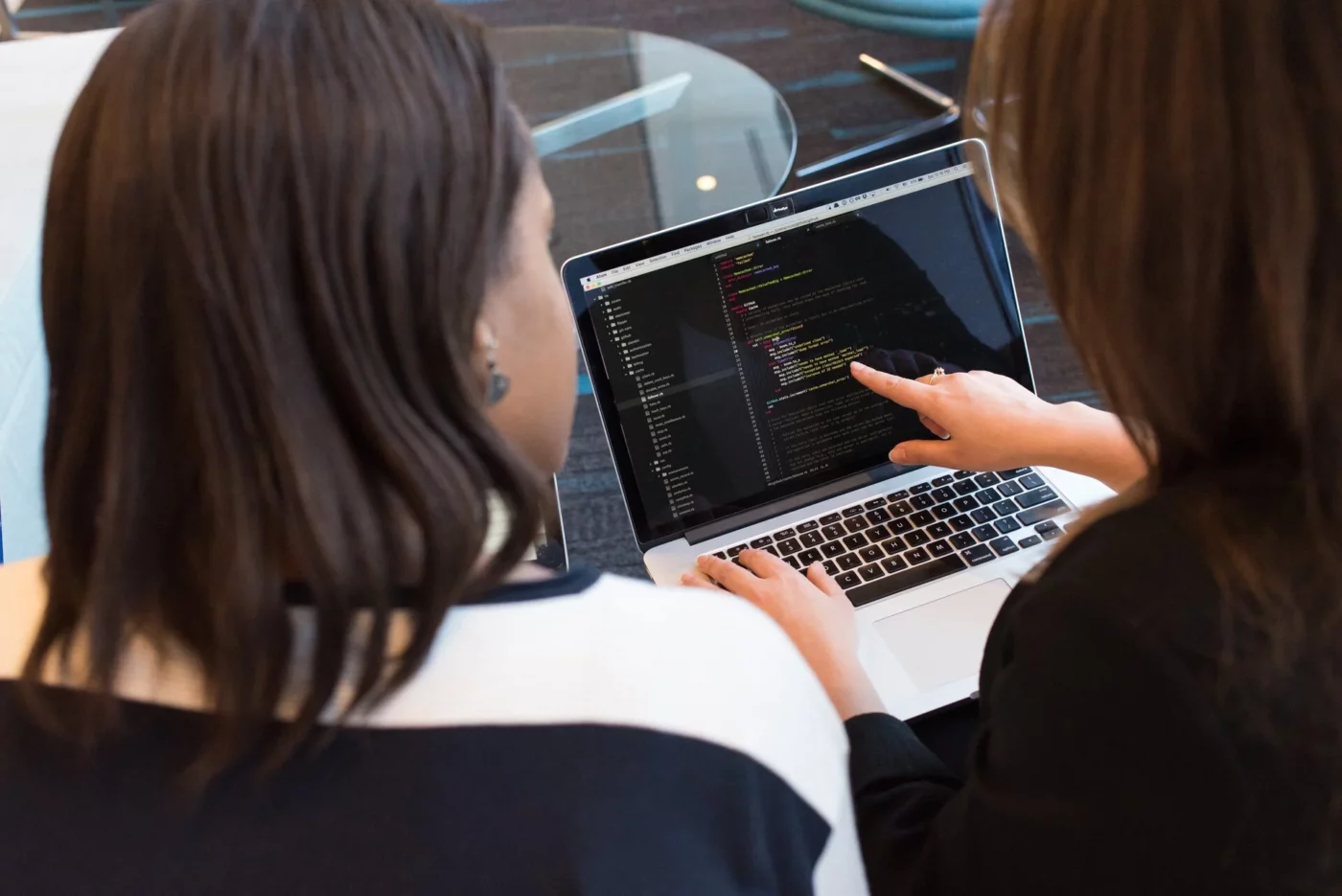 Two women looking at a code