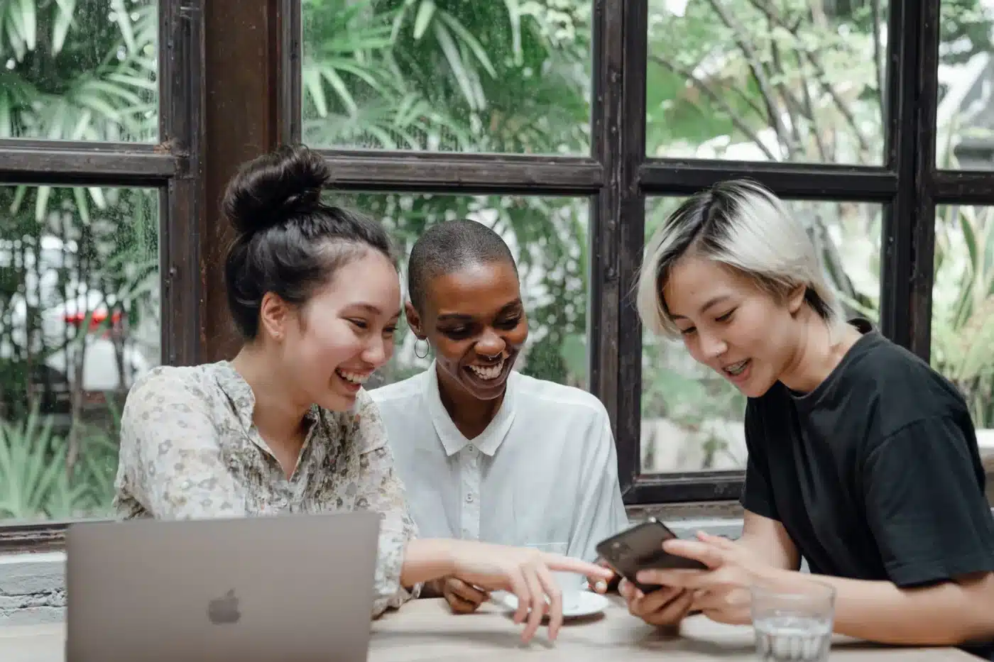 Women looking at a phone at a cafe