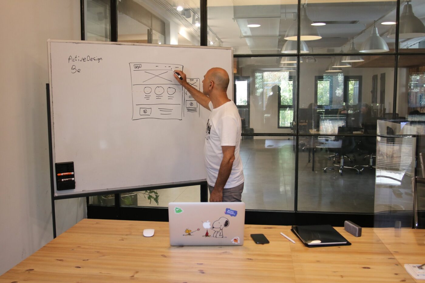 A man focusing on a design on a whiteboard