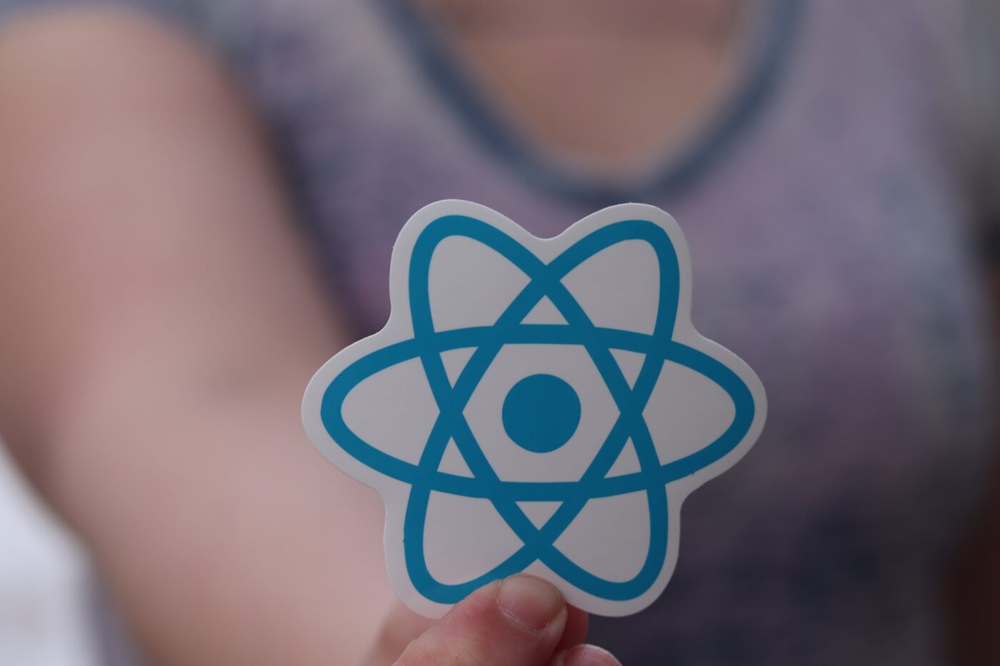 A person holding a React sticker