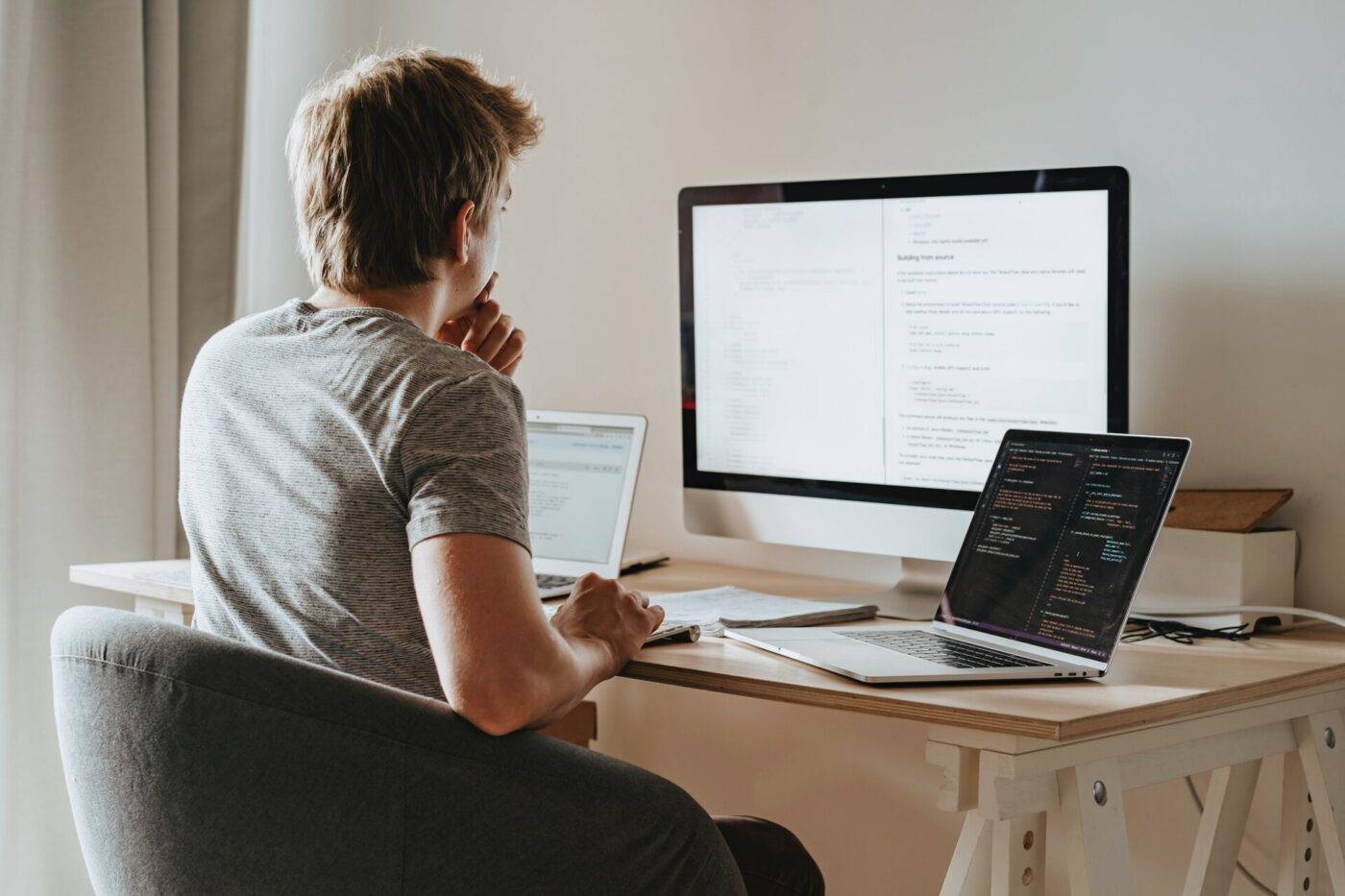 A young man sitting in front of computers